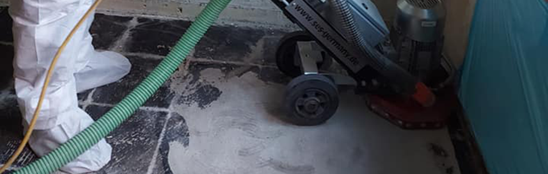 Bodenfräsmaschine mit angeschlossener Absaugung bei der Entfernung belasteter Kleberreste
