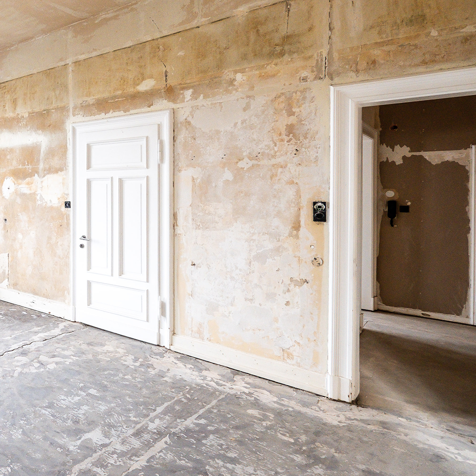 Innenraum während einer Sanierung mit freigelegten Wand- und Bodenflächen
